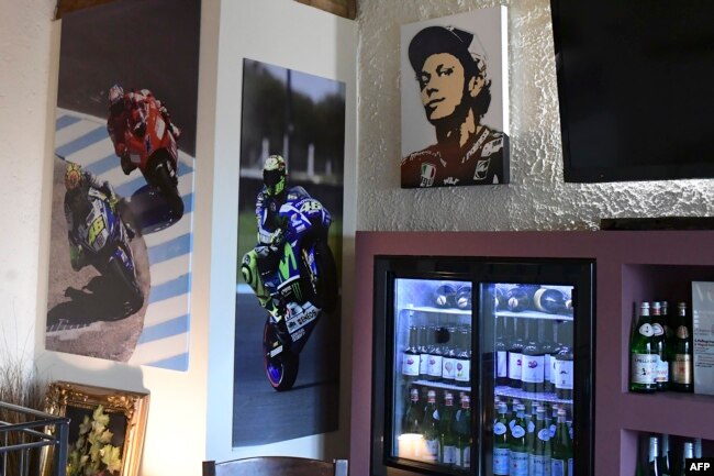 Gambar balap dan potret pembalap motor Italia Valentino Rossi dipajang di restoran dan toko Rossi di kampung halamannya di Tavullia, pada 29 Januari 2019. (Foto: AFP)