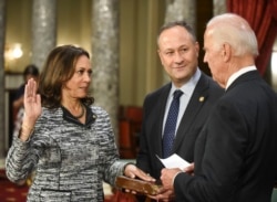 Vice President Joe Biden administers the Senate oath of office to Sen. Kamala Harris, D-Calif., as her husband Douglas Emhoff, holds the Bible during a a mock swearing in ceremony in the Old Senate Chamber on Capitol Hill in Washington.