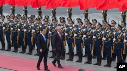 Australian Prime Minister Malcolm Turnbull, center right, walks with Chinese Premier Li Keqiang, during a welcome ceremony outside the Great Hall of the People in Beijing, China, April 14, 2016. 