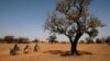 FILE - Girls carry water on their bicycles at a dispensary in Nedogo village near Ouagadougou, Burkina Faso, Feb. 16, 2018.