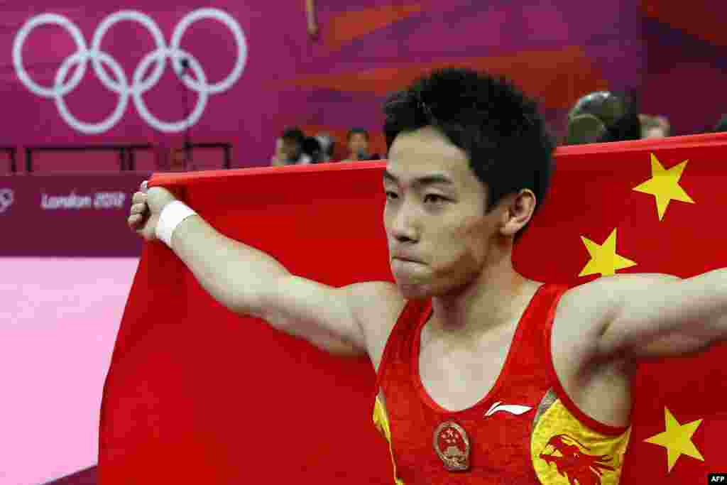 China's gymnast Zou Kai celebrates with his national flag after winning the men's floor exercise final of the artistic gymnastics event of the London Olympic Games on August 5, 2012 