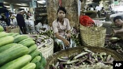 A woman sells produce at a vegetable wholesale market in Yangon (file photo – 25 Apr 2010)