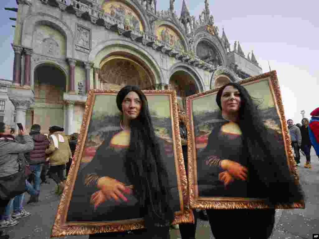 Two people dress as Leonardo da Vinci&#39;s painting &#39;Mona Lisa&#39; in St. Mark&#39;s Square in Venice, Italy.