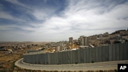 A section of the controversial Israeli barrier is seen from Jerusalem and shows the Shuafat refugee camp (R) in the West Bank near Jerusalem, and Pisgat Zeev (L) in an area Israel annexed to Jerusalem after capturing it in the 1967 Middle East war (File P