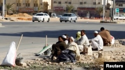 Foreign construction laborers rest on a street in Riyadh, Dec. 3, 2012.