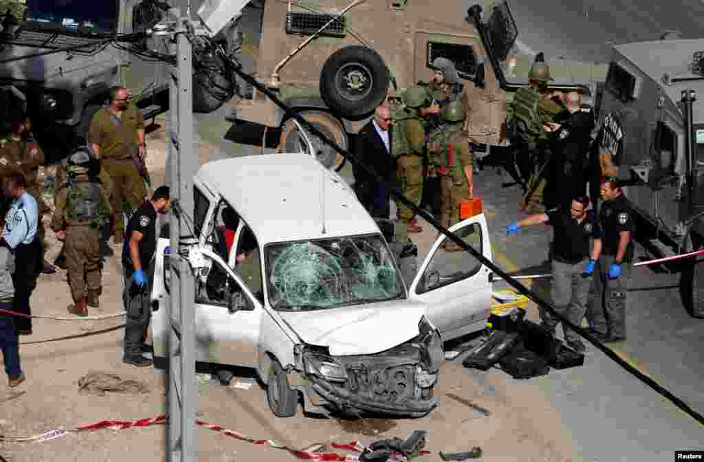 Israeli policemen inspect the scene of a car ramming attack near Hebron, in the occupied West Bank.