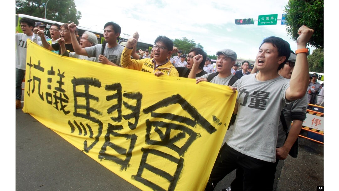 Opposition protesters shout slogans behind a banner opposing the planned meeting of Taiwan's President Ma Ying-jeou with his China counterpart Xi Jinping in Taipei, Taiwan, Nov. 4, 2015.