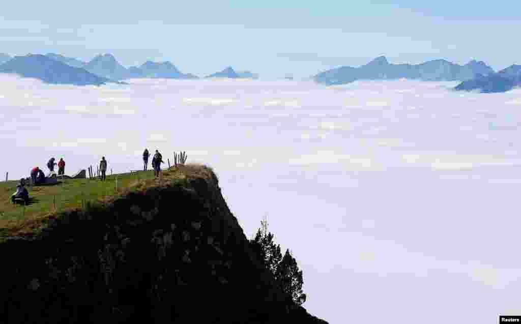 Para turis berjalan di pegunungan Niederhorn, dekat kota Interlaken, Swiss.