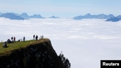 Wisatawan berjalan di bawah sinar matahari di gunung Niederhorn dekat Interlaken, Swiss, 5 Oktober 2016. (Foto: Reuters)