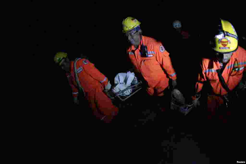 Rescuers carry the body of one of the victims killed in a landslide after a 7.4-magnitude earthquake in El Recreo,Guatemala, November 7, 2012. 