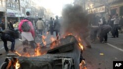 This photo, taken by an individual not employed by the Associated Press and obtained by the AP outside Iran shows Iranian protestors attending an anti-government protest as a garbage can is set on fire, in Tehran, Iran, Monday, Feb. 14, 2011.