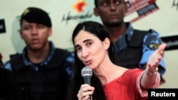 Custodiada por guardias de seguridad, Yoani da una rueda de prensa entre admiradores suyos y simpatizantes del régimen cubano.
