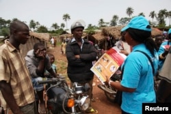 A UNICEF worker talks with motorcycle taxi drivers about Ebola and precautions in Voinjama, Liberia, in this UNICEF handout photo.