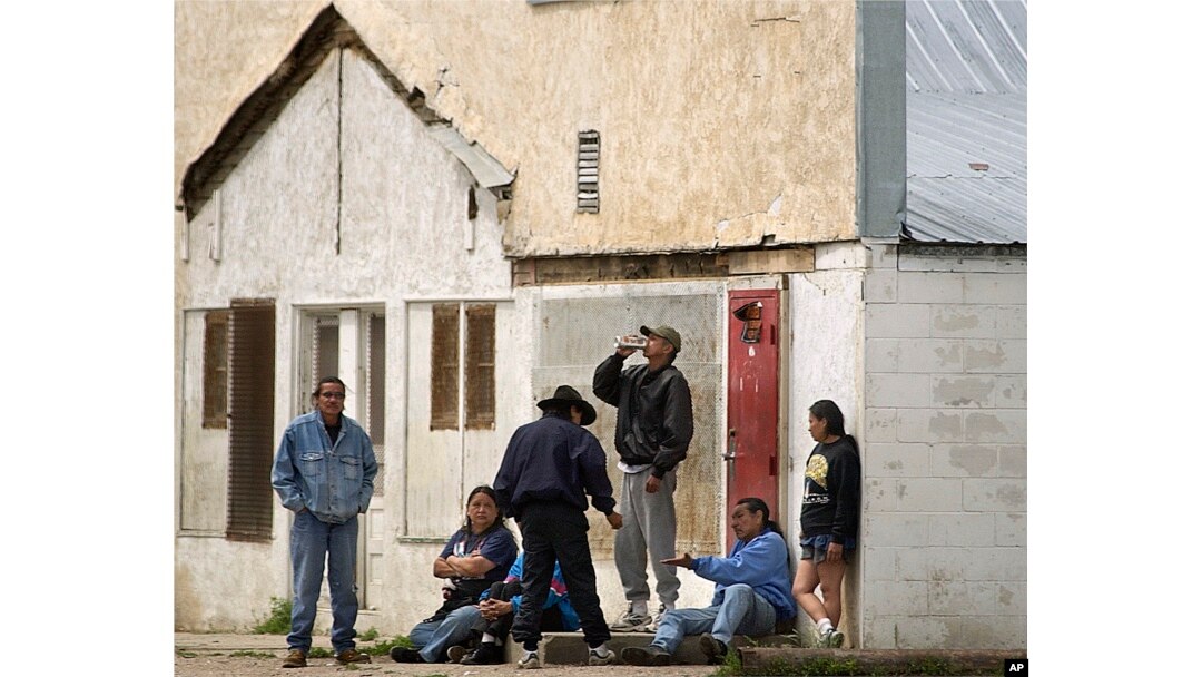FILE - Individuals consume beer on the streets of Whiteclay, Neb., Saturday afternoon, June 7, 2003. The unincorporated town of 12 people sells 4 million cans of beer a year, mostly to residents of the nearby Pine Ridge Indian Reservation.