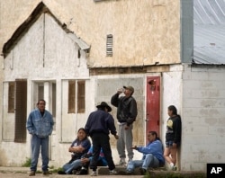 FILE - Individuals consume beer on the streets of Whiteclay, Neb., Saturday afternoon, June 7, 2003. The unincorporated town of 12 people sells 4 million cans of beer a year, mostly to residents of the nearby Pine Ridge Indian Reservation.