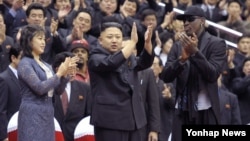 Presiden Korea Utara Kim Jong Un bersama isterinya (kiri) menerima kunjungan mantan bintang NBA, Dennis Rodman (kanan) di Pyongyang.