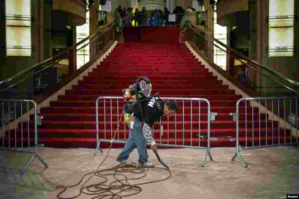 A man uses a vacuum along the red carpet ahead of the 86th Academy Awards in Hollywood, California, March 1, 2014.&nbsp;