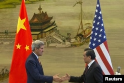 U.S. Secretary of State John Kerry, left, and Chinese Foreign Minister Wang Yi shake hands after a news conference following meetings at the Ministry of Foreign Affairs in Beijing, May 16, 2015.
