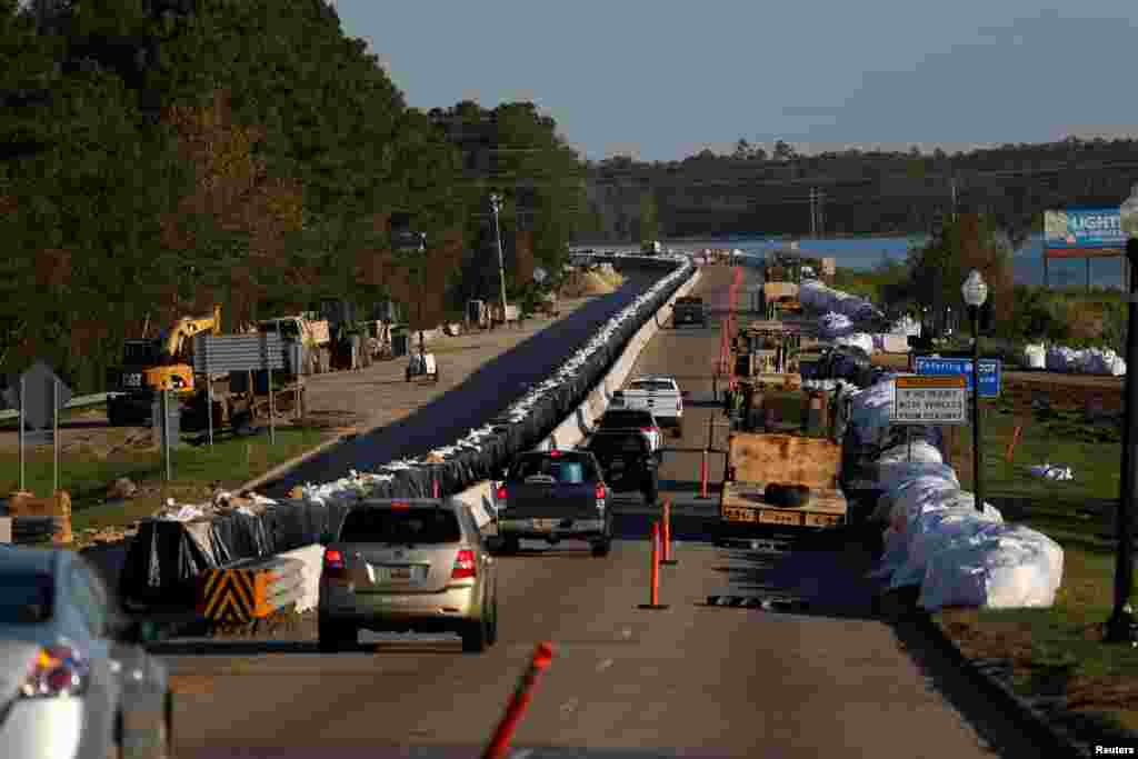 Traffic moves past a sandbag flood barrier being built on U.S. 501 by the South Carolina Department of Transportation to lesson damage to roads anticipated from floods caused by Hurricane Florence, now downgraded to a tropical depression, in Conway.