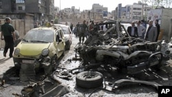 People look at destroyed and damaged vehicles after an explosion on al-Thawra Street in Damascus, Syria, May 5, 2012. 