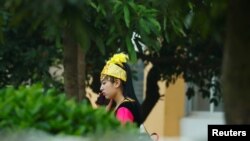 A woman in Uyghur ethnic dress stands inside the compound of Universal Electronics Inc. in Qinzhou, Guangxi Autonomous Region, China, April 13, 2021.