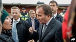 Le Premier ministre suédois Stefan Löfven rassurant des parents près d'une école où un homme a poignardé quatre personnes à Trollhattan, en Suède, le 22 octobre 2015.