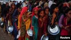 Flood victims gather to receive food handout in a camp, following rains and floods during the monsoon season in Sehwan, Pakistan September 15, 2022. (REUTERS/Akhtar Soomro)