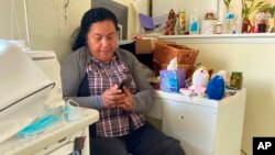 Rosalidia Dardon, 54, looks at a picture of her daughter in El Salvador as she sits in a refugee house in Texas, awaiting asylum or a protected immigration status on Nov. 4, 2021. (Acacia Coronado/Report for America via AP)