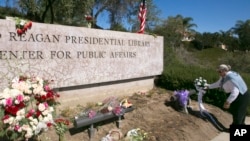 Katherine Collins, a former library docent, brings a bouquet of white roses to the Ronald Reagan Presidential Library, March 8, 2016, in Simi Valley, Calif. Former first lady Nancy Reagan died March 6, at 94.