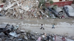 Anak-anak tampak berjalan di salah satu area yang hancur di Kota Tyre, Lebanon, pada 28 November 2024. (Foto: Reuters/Aziz Taher)