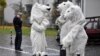 Manifestantes disfrazados de osos polares conversan luego de una protesta bajo la mirada de un policía en una calle cercana a la Conferencia COP 23 Fiji de la ONU para el Cambio Climático, en Bonn, Alemania. Nov. 11, 2017.