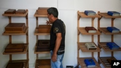 A worker at the Humidors Habana Art Creation Workshop shows cigar humidifiers in Havana, Cuba, Feb. 19, 2025.