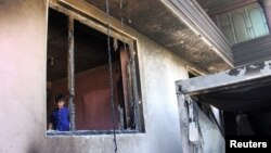 An Afghan boy is seen inside a burnt building after a Taliban attack in Ghazni city, Afghanistan, Aug. 15, 2018. 