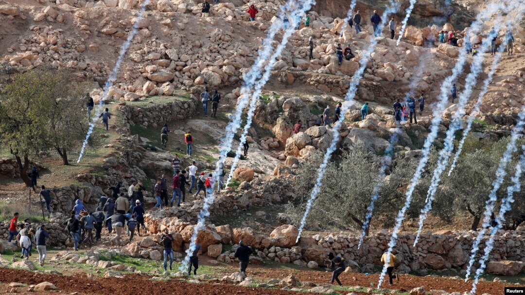 Tear gas canisters are fired by Israeli troops towards Palestinians during a protest against Israeli land seizures for Jewish settlements, near Ramallah in the occupied West Bank, Nov. 30, 2018.