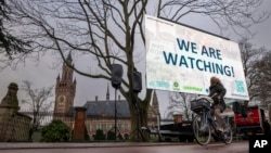 Aktivis berunjuk rasa di luar Mahkamah Internasional (kiri), di Den Haag, Belanda, Senin, 2 Desember 2024. (Peter Dejong/AP)