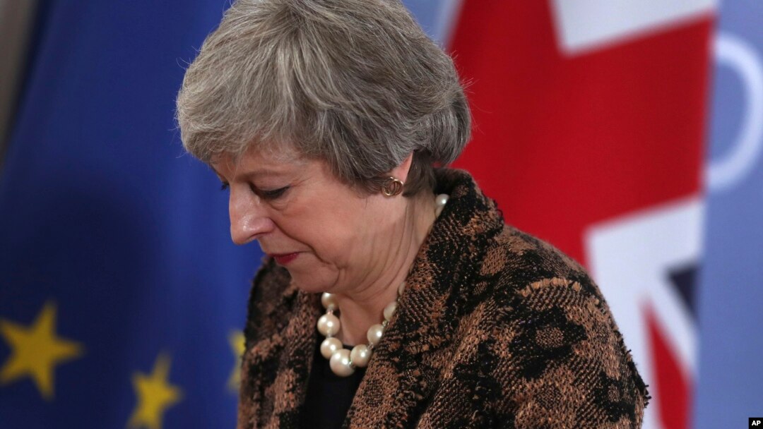 British Prime Minister Theresa May walks by the Union flag and the EU flag as she departs a media conference at an EU summit in Brussels, Dec. 14, 2018. 