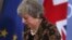 British Prime Minister Theresa May walks by the Union flag and the EU flag as she departs a media conference at an EU summit in Brussels, Dec. 14, 2018. 