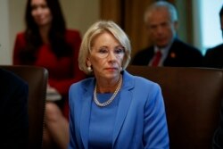 FILE - Education Secretary Betsy DeVos listens during a Cabinet meeting in the Cabinet Room of the White House in Washington, July 16, 2019.