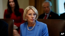 FILE - Education Secretary Betsy DeVos listens during a Cabinet meeting in the Cabinet Room of the White House in Washington, July 16, 2019. 