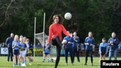Britain&#39;s Catherine, Duchess of Cambridge reacts as she plays Gaelic football during a visit to the local Salthill Knocknacarra Gaelic Athletic Association Club (GAA) in Galway, Ireland.