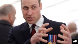 Britain's Prince William gestures as he meets veterans and serving members of the British armed forces at a reception following an unveiling of a national memorial honoring the Armed Forces and civilians who served their country during the Gulf War and co