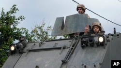 A Lebanese army soldier flashes victory sign, as a convoy enters in Mansouri village on its way to being deployed in southern Lebanon, following a cease-fire between Israel and Hezbollah that went into effect, Nov. 27, 2024.