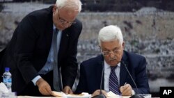 Presiden Palestina Mahmoud Abbas (kanan) menandatangani proposal untuk pengakuan dari PBB di Tepi Barat (1/4), meskipun sebelumnya telah berjanji untuk menangguhkan hal itu dalam 9 bulan negosiasi dengan Israel. Pengajuan ini dilakukan setelah Israel tidak membebaskan tawanan Palestina seperti disepakti sebelumnya. 