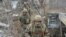 FILE - Service members of the Ukrainian armed forces walk on the line of separation from pro-Russian rebels near Donetsk, Ukraine, April 11, 2021.