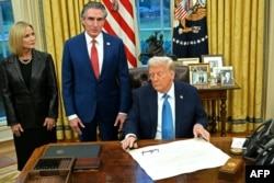 U.S. President Donald Trump speaks to the press after after signing an executive order alongside U.S. Secretary of the Interior Doug Burgum and his wife, Kathryn Burgum, in the Oval Office of the White House in Washington on Jan. 31, 2025.