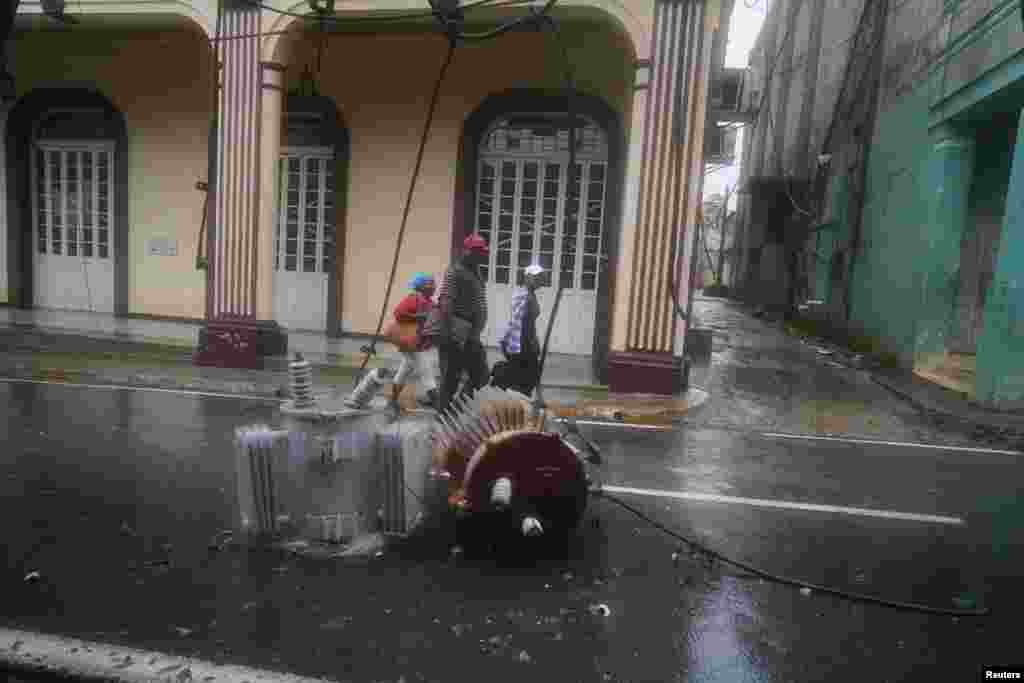 La gente pasa por un transformador eléctrico en la calle después del huracán Ian en Pinar del Río, Cuba, 27 de septiembre de 2022. REUTERS/Alexandre Meneghini