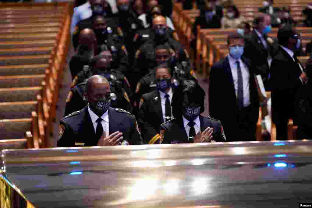 Members of the Texas South University police department pause by the casket of George Floyd during a funeral service at the Fountain of Praise church, in Houston, Texas.