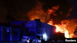 2026년 4월 16일 우크라이나 키이우에서 러시아의 우크라이나 공격 중 발생한 러시아의 미사일 공습으로 파손된 경찰차와 구급차 옆에 한 경찰관이 서 있다.