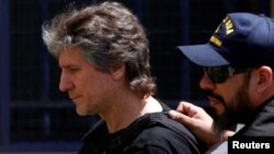 Former Argentine Vice President Amado Boudou is escorted by a member of Argentina's Coastguards as he arrives to a Federal Justice building in Buenos Aires, Argentina, Nov. 3, 2017. 