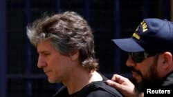 Mantan Wakil Presiden Argentina Amado Boudou dikawal oleh anggota penjaga pantai Argentina setibanya di gedung pengadilan federal di Buenos Aires, Argentina, 3 November 2017.